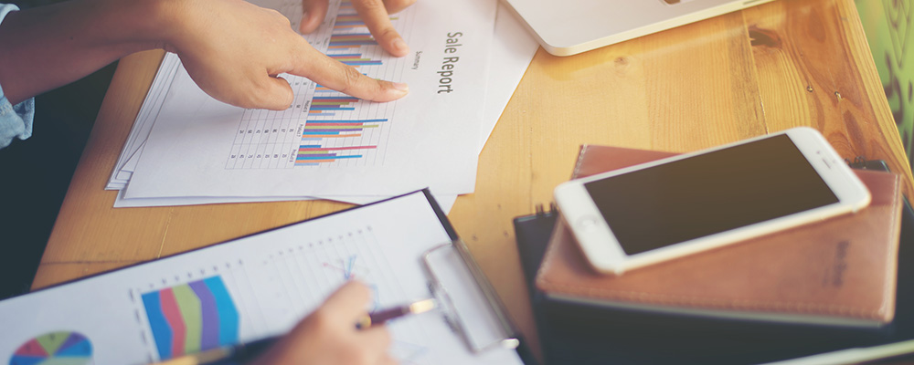 Business team meeting analysis financial chart together at cafe.