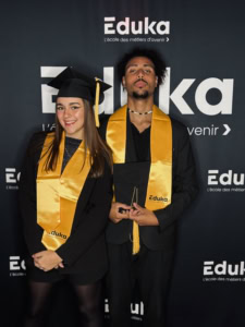 Un étudiant et une étudiante qui pose pour la photo de la remise des diplômes